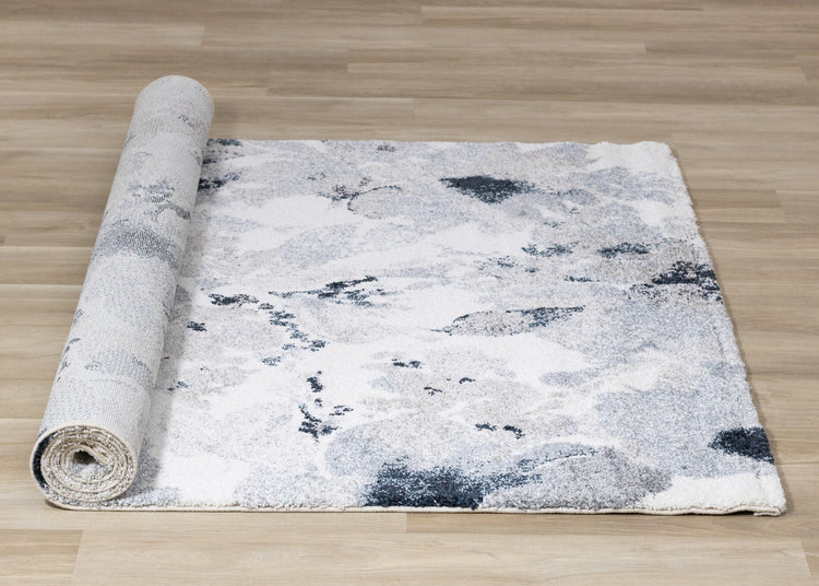 Alfombra gris sable con estampado floral azul crema de Kalora Interiors