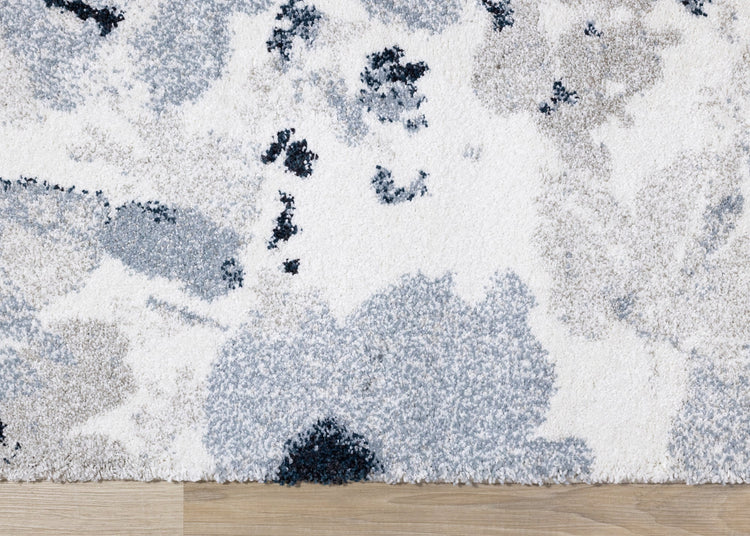 Alfombra gris sable con estampado floral azul crema de Kalora Interiors