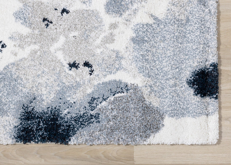 Alfombra gris sable con estampado floral azul crema de Kalora Interiors